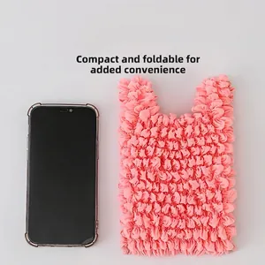 Pink pleated bubble shopping bag folded to a compact size next to a smartphone