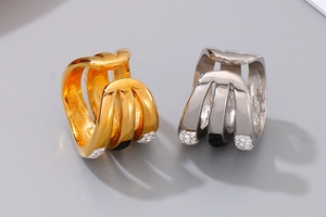 Macro shot of geometric gold and silver rings with fine diamond settings on grey background