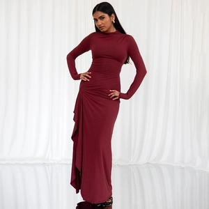 Detailed view of the side ruffle drape and textured fabric on red long sleeve slim dress