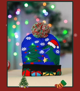 Detail of LED knit Christmas hat with dinosaur pattern and colorful pom-pom top