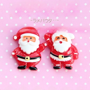Flat lay of two miniature Santa Claus resin cabochons for Christmas DIY crafts and jewelry