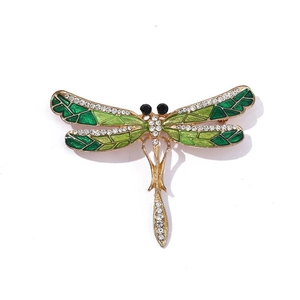 Detail of dragonfly brooch with green enamel wings and sparkling crystal accents