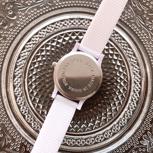 Detail view showing the stainless steel back of a child's watch with a white silicone strap