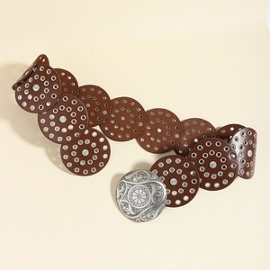 Detail of a brown leather belt with silver rings and a large floral carved metal buckle