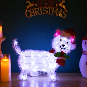 Close-up of lighted Christmas cat figure with warm LED glow and holiday decorations