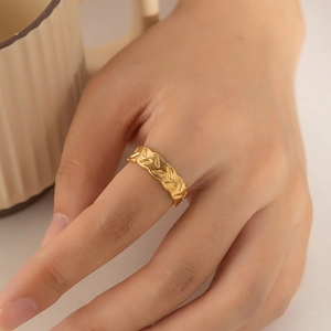 Detail of a vintage-style gold plated ring with leaf pattern worn on the finger