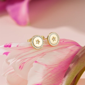 Macro shot of 925 silver round gold studs with star pattern on pink flower petals