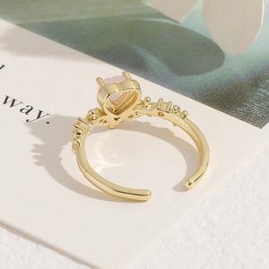 Adjustable golden ring featuring pink heart gemstone and sparkling side accents