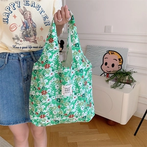 Dettaglio della borsa tote in tela a fiori con etichetta tessuta e manico integrato chic