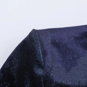 Dettaglio ravvicinato del tessuto in velluto blu scuro e ricami del vestito midi