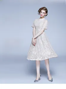Détail de la robe en dentelle blanche avec broderie florale et texture ajourée élégante