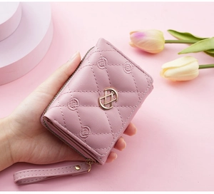 Detail of pink embroidered wallet with quilted leather and golden metal clasp decoration