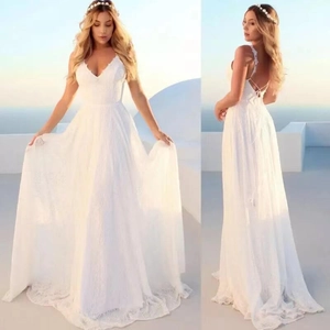 Elegant white lace V-neck wedding dress with open back and crossed straps on blue sea background