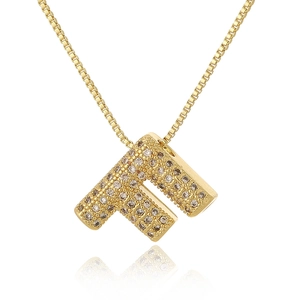Macro shot of gold letter F pendant with micro-paved zircons and elegant reflection