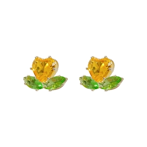 Silver flower jewelry set with yellow heart stones and green leaves on white background