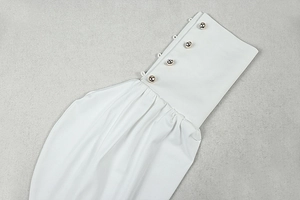 Détail du poignet d'une manche longue blanche avec quatre boutons dorés décoratifs