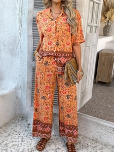 Détail de l'imprimé fleuri bohème sur l'ensemble deux pièces en lin orange à pantalon large