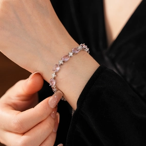 Detail of pink zircon flower bracelet on wrist with sparkling oval stones and silver finish