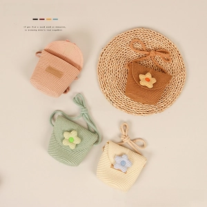 Detail of colorful hand-woven straw crossbody bags for kids with cute floral decorations