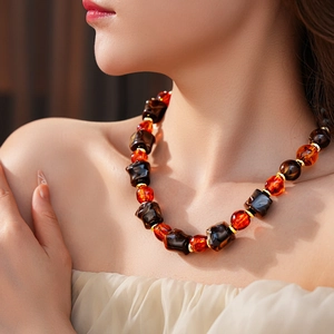 Macro shot of irregular amber-style resin beads with gold spacers on a chunky necklace