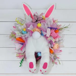 Detailed view of Easter bunny wreath with faux carrots, colorful eggs and plush rabbit legs