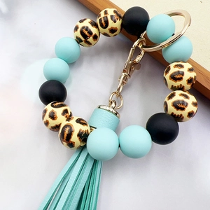 Leopard print and blue silicone bead wristlet keychain with leather tassel on marble background