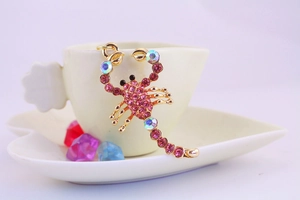 Dettaglio portachiavi a scorpione in cristallo con strass rosa su base d'oro