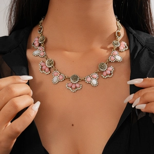 Close-up of vintage resin flower necklace with pink rhinestones on a female model