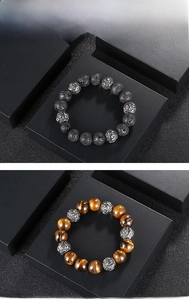 Detailed close-up of tiger eye and lava stone beaded bracelets with silver ethnic charms