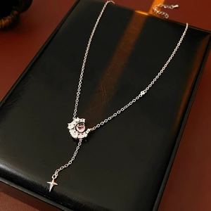 Gros plan du collier en Y argenté avec étoiles, lunes et pierres de zircon rose