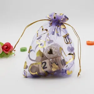 Detail of purple organza drawstring bag with gold heart patterns and metallic cord