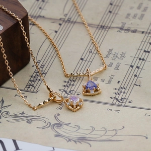Dettaglio di due collane d'oro vintage con pietre blu e opali su uno spartito musicale