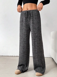Detail of dark grey drawstring waistband and knit texture on wide-leg trousers