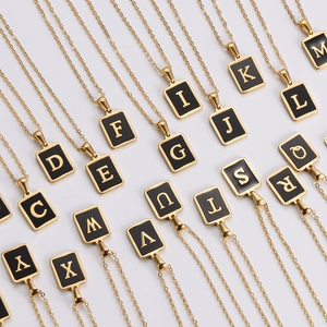 Detailed array of vintage gold letter necklaces with black enamel square pendants