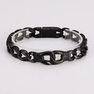 Detailed macro view of black matte metal chain bracelet with embossed totem patterns