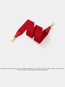 Close-up of 5cm wide red woven canvas strap with gold hardware for crossbody bags