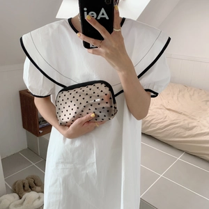 Detail of hand-held mesh pouch featuring heart patterns and black zipper closure