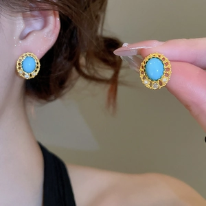 Detail of vintage gold earrings with oval turquoise, pearls and clear gemstone studs