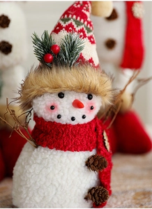 Detail of Christmas snowman figurine with red knit scarf, pine cones and rustic branch arms