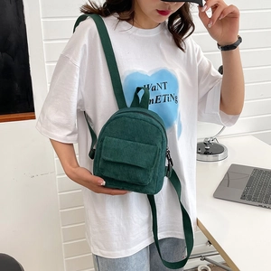 Detail showing the dark green corduroy material and compact design of the stylish backpack