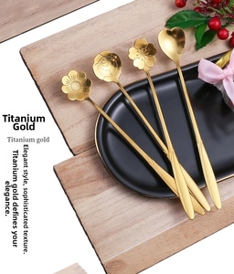 Detailed macro shot of four creative gold flower shaped stainless steel spoons on a tray