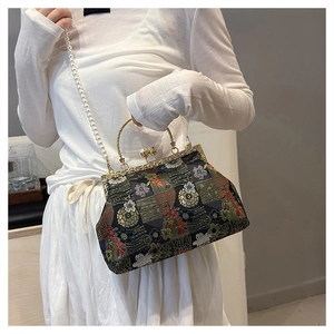 Close-up of floral embroidery on vintage evening bag with pearl chain and metal clasp