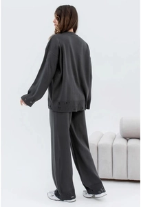 Back view of distressed dark grey knit set featuring oversized top and wide-leg trousers
