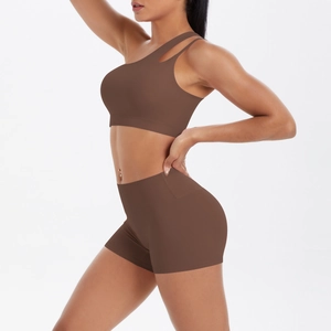 Detailansicht eines dunkelbraunen One-Shoulder-Sport-BHs und hoch taillierter Yoga-Shorts