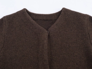 Detail shot of a dark brown faux fur knit jacket with V-neckline and single button