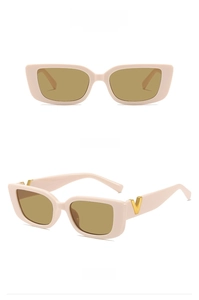 Macro view of light pink square sunglasses with golden V detail and brown lenses