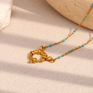 Detail of 18K gold plated necklace with blue beads and a round spring clasp design