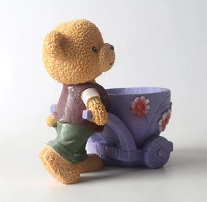 Dettaglio statuetta orsetto con vasetto a carrello viola e decorazioni floreali