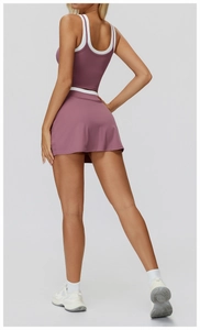 Two-piece dry rose pink yoga set with white trim, featuring a racerback tank and mini skirt