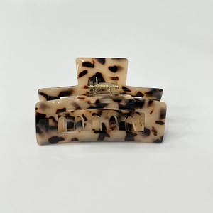 Macro detail of tortoiseshell hair claw clip with glossy finish on a white background